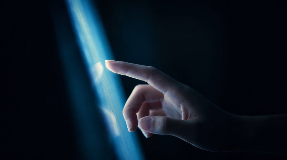 Hand reaching toward a beam of light in the dark